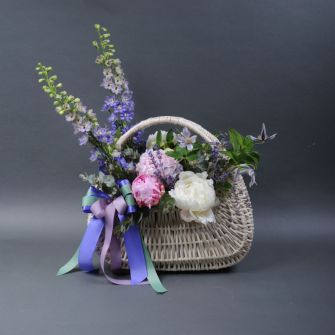 Композиція з піонами в кошику